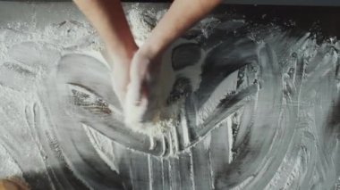 Erkek aşçının yemek hazırlarken masaya un serptiği sahneyi büyüt.