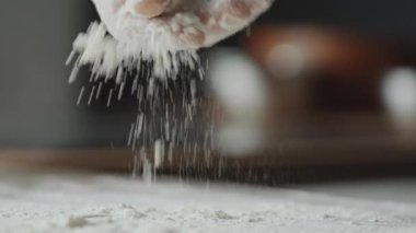 Erkek elinin masaya un serptiği seçici odak noktasını kapat.