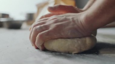 Mutfak masasında hamur yoğuran fırıncının ellerini kapat.