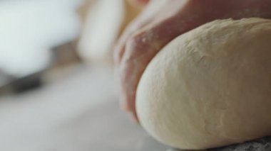 Hamuru yoğuran fırıncının ellerinin Hollanda açılı çekimini kapat