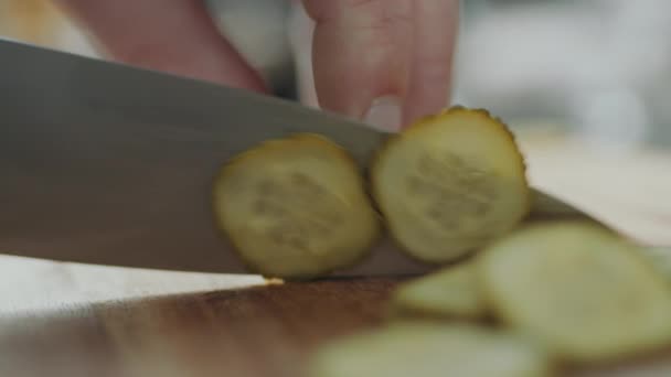 木製ボード上のナイフでスライスにディル漬物を切断シェフの手のショットを閉じます — ストック動画