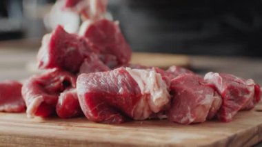 Kasap 'ın tahta kesme tahtasına çiğ et koyduğu seçici odak noktasını kapat.