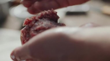 Hamburger köftelerini hazırlarken erkek ellerinin köfte oluşturduğu yakın çekim.