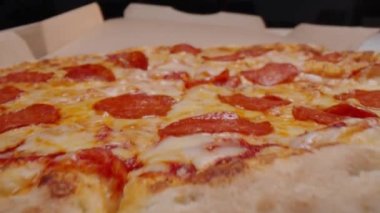 Pakette taze pişmiş pepperonili pizzanın yakın çekim görüntüsü.