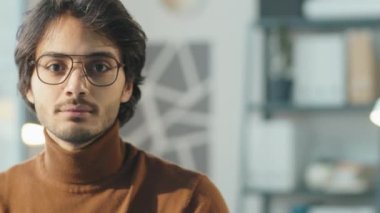 Gözlüklü genç ortadoğulu iş adamının portresi ofiste dikilip kameraya bakıyor.