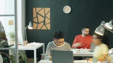 Modern açık uzay ofisinde çalışan çok ırklı iş adamları ve iş kadınlarının zaman aşımı. Meslektaşlar gazete okur, dizüstü bilgisayar kullanır ve iş tartışır.