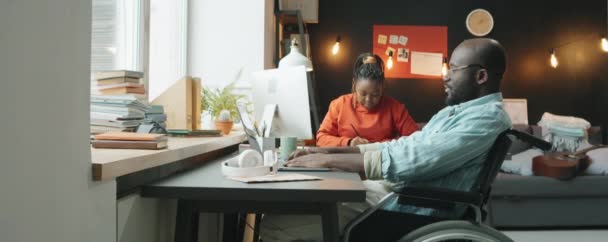Tekerlekli Sandalyede Oturan Bilgisayarında Yazı Yazan Ofiste Birlikte Çalışırken Bayan — Stok video