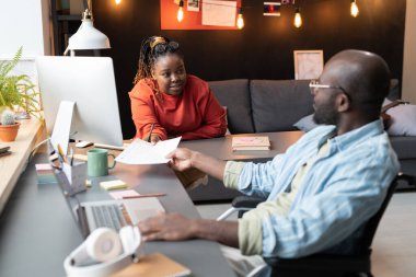 Ofiste iş arkadaşıyla çalışan engelli bir adam.
