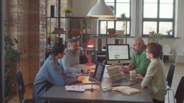 Bir grup deneyimli iş adamının çalışma masasında tartışmalarını yakınlaştır.