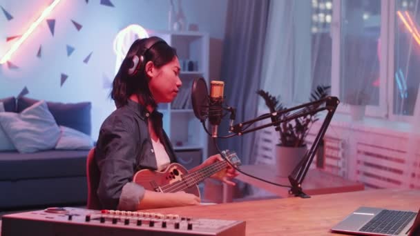 Jeune Femme Asiatique Dans Casque Assis Bureau Jouant Guitare Chantant — Video