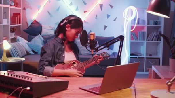 Jeune Chanteuse Asiatique Dans Casque Assis Bureau Jouant Guitare Chantant — Video