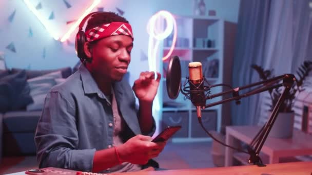 Junger Cooler Afroamerikaner Mit Kopfhörer Hält Smartphone Der Hand Und — Stockvideo