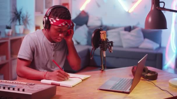 Mladý Afroameričan Sluchátkách Sedí Stolem Domácím Nahrávacím Studiu Pohybuje Hlavou — Stock video