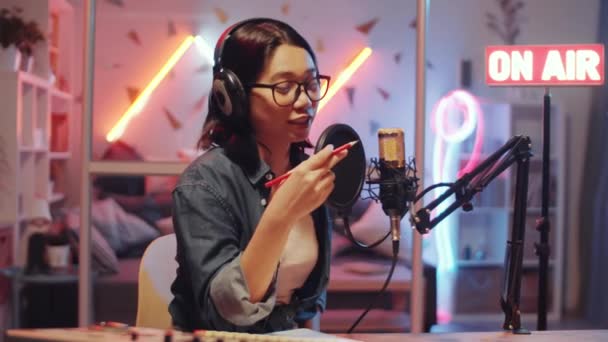 Mujer Asiática Joven Que Pone Auriculares Habla Micrófono Mientras Graba — Vídeo de stock