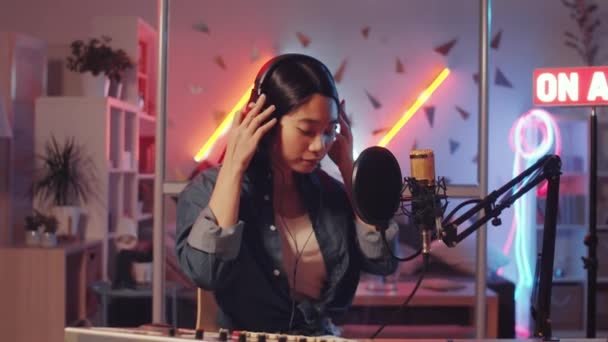 Feliz Joven Mujer Asiática Quitándose Los Auriculares Mirando Cámara Sonriendo — Vídeo de stock