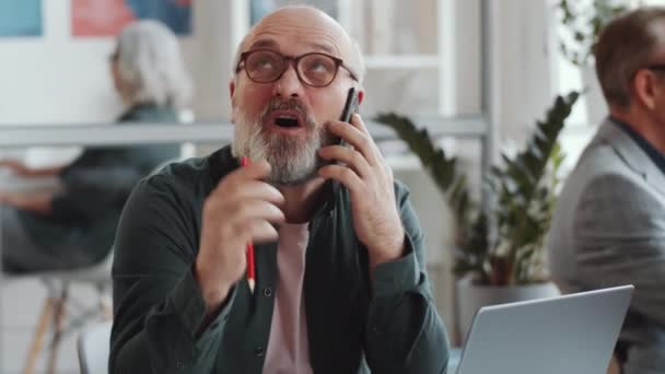 Fröhlicher Senior Geschäftsmann Plaudert Mit Handy Laptop Und Notizblock Während — Stockvideo