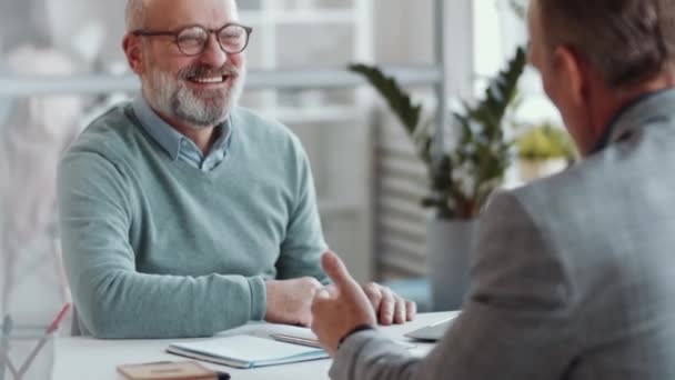 Nad Ramieniem Zdjęcia Pozytywnego Starszego Mężczyzny Uśmiechającego Się Rozmawiającego Współpracownikiem — Wideo stockowe