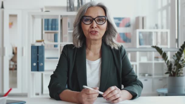 Schöne Seniorin Formalbekleidung Und Brille Sitzt Schreibtisch Büro Schaut Die — Stockvideo