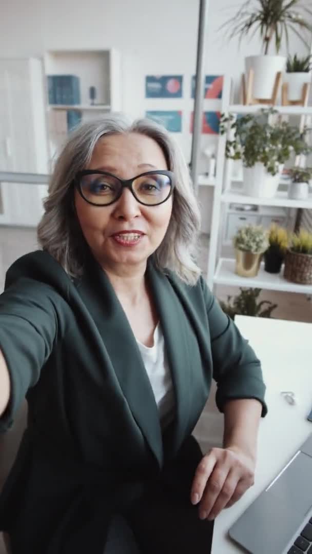 Vertikal Bild Attraktiva Senior Affärskvinna Tittar Kameran Vinka Och Chatta — Stockvideo