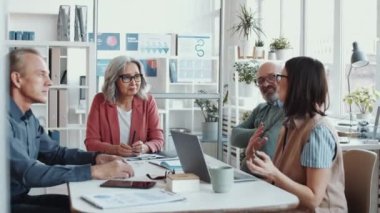 Bir grup yaşlı iş adamı ve kıdemli bayan patron ofiste toplantı masasında birlikte oturup iş günlerinde tartışıyorlar.