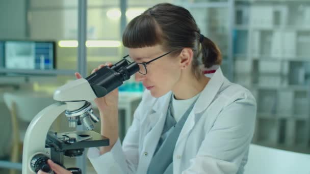 Mujer Científica Bata Blanca Mirando Través Del Microscopio Mientras Conduce — Vídeos de Stock