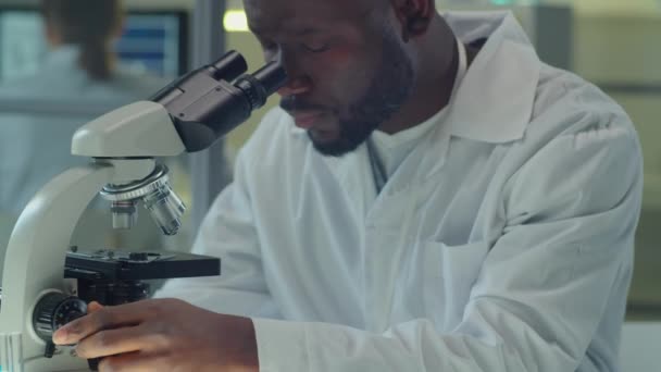 Tilt Shot Van Afro Amerikaanse Wetenschapper Labjas Zitten Aan Het — Stockvideo