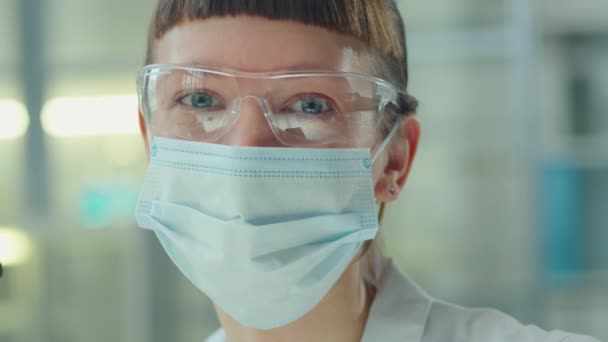化验室中戴无菌面罩 戴护目镜的年轻女科学家画像 — 图库视频影像