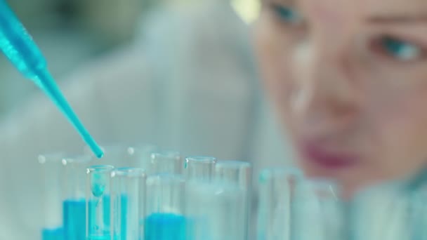 Close Rack Focus Shot Van Vrouwelijke Wetenschapper Gieten Blauwe Vloeibare — Stockvideo
