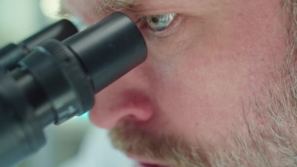 Close Shot Van Bebaarde Wetenschapper Kijken Door Microscoop Vertellen Iets — Stockvideo