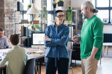 İş arkadaşları ofiste konuşuyor.