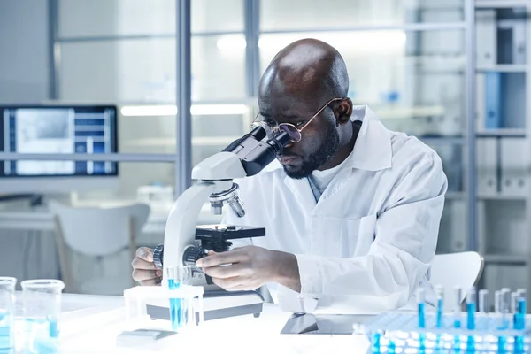 Científico trabajando con microscopio en el laboratorio — Foto de Stock