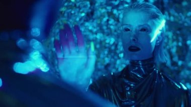 Siyah gözlü, siyah rujlu, parlak elbiseli, mavi lazer ışığı ve hipnotize eden adamla aynı odada duran uzaylı kadının omzunun üstünden.