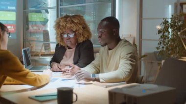 Çeşitli meslekdaşlardan oluşan bir ekip iş projesini tartışırken gece boyunca ofiste çok çalışıyor.