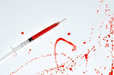 Beyaz arka planda kan lekeleri olan şırınga iğnesi, ilaç, uyuşturucu bağımlılığı, cinayet.