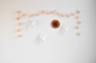 Kağıt yıldızlı ev dekorasyonu, duvara örgü toplar, el yapımı aksesuarlar. Retro konforlu ev dekorasyonu. scandi-boho tarzı.