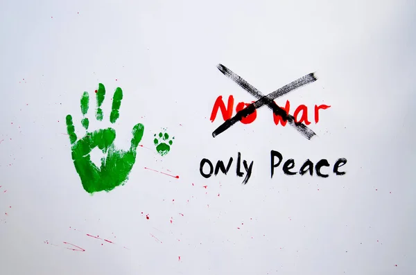 Photo of No war text with handprint and dog\'s paw print on white background,soft focus. Green handprint of human and dog\'s paw print with red drops