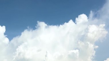 Arkaplanı hareket eden bulutlarla dolu güzel bir gökyüzü. Kabarık beyaz bulutlar. Bulut zamanı, doğa geçmişi. Kümülüs bulutlu zaman çizelgesi. Doğanın mavi gökyüzü kopyalama alanı ile.
