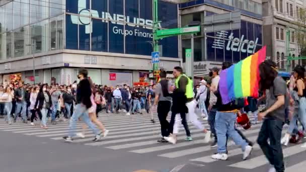 メキシコ市2021年6月 ルブトプライド行進中にマデロ通りを横断する人々は メキシコ市のゾカロに向かう虹の旗を持っている人々を見ることができます — ストック動画