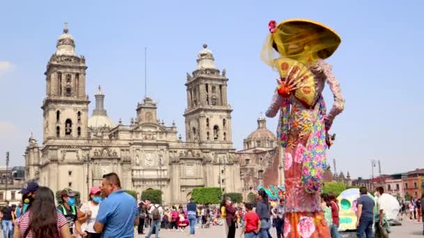 2021年11月 墨西哥城 人们在首都的Zocalo上行走 在那里可以看到白内障和骷髅的雕塑 也可以看到大都会大教堂 — 图库视频影像