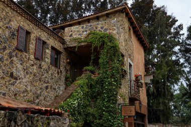Tlaxcala, Meksika - Haziran 2021: Turistlerin uluslararası gıda restoranlarında yürüyebildikleri ve yiyebildikleri güzel Avrupa mimarisine sahip Val 'Quirico kasabasındaki bir otelin cephesi.