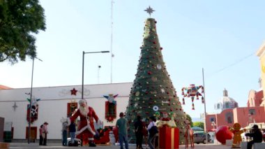 Tlaxcala, Meksika - Ocak 2022: Aileler Noel ağacında ve Noel Baba ile birlikte Tlaxcala eyaletinin hükümet sarayının yanında fotoğraf çekiyorlar.