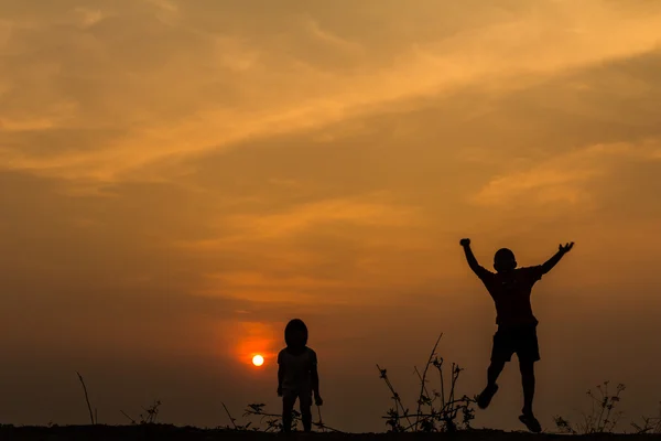 Silhouette, group of happy children playing on meadow, sunset, s — Stock Photo, Image