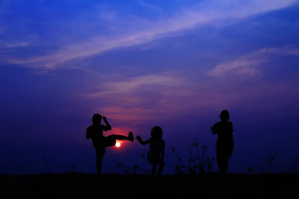 Gruppe fröhlicher Kinder, die auf der Wiese spielen, blauer Himmel, Sommer Stockbild