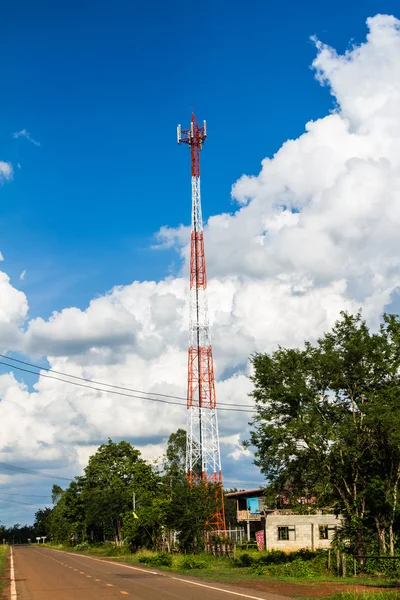 Mobilní telefon a komunikační věže proti modré obloze — ストック写真