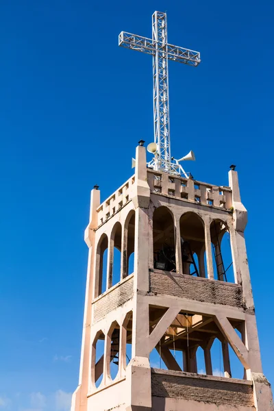 Kreuz auf dem Glockenturm der modernen christlichen Kirche unter blauem Himmel — Stockfoto