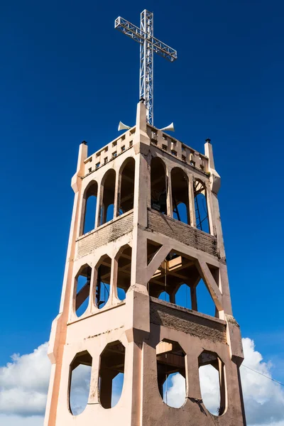 Крест на колокольне современной христианской церкви под голубым небом — стоковое фото