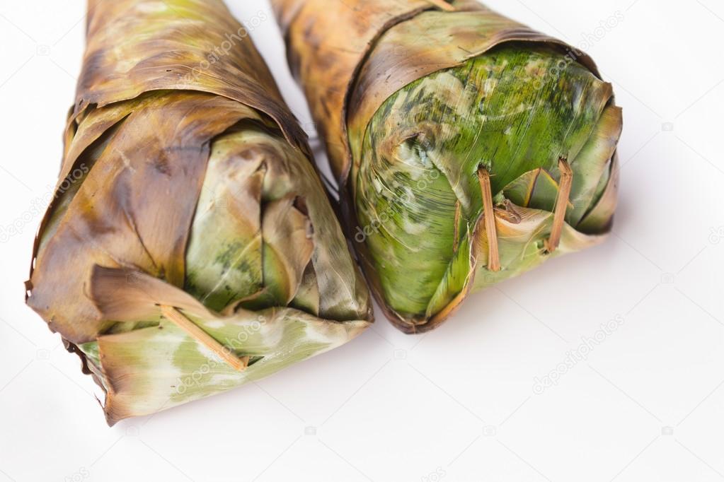 Asado de arroz pegajoso, envuelto en hojas de plátano y fondo blanco 2022