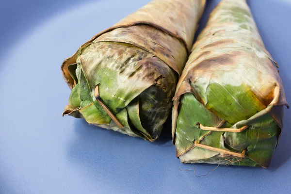 Kleefrijst geroosterd, ingepakt in bananenbladeren. — Stockfoto