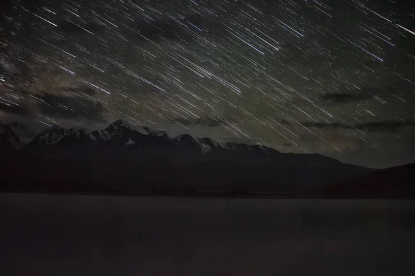 雪の山 水の中の星の反射の上に夜空のトラックの形で星と素晴らしい景色 ロシアのアルタイ — ストック写真