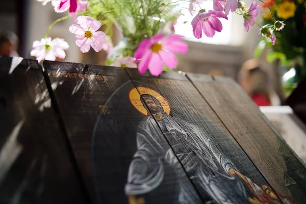 İsa 'nın dirilişinin ahşap simgesi. Pembe kır çiçekleriyle çevrili.